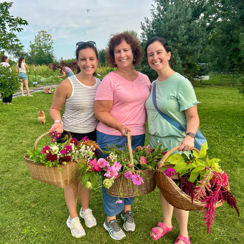 Three women holding baskets of flowers at First Roots Farm Oconmowoc WI 